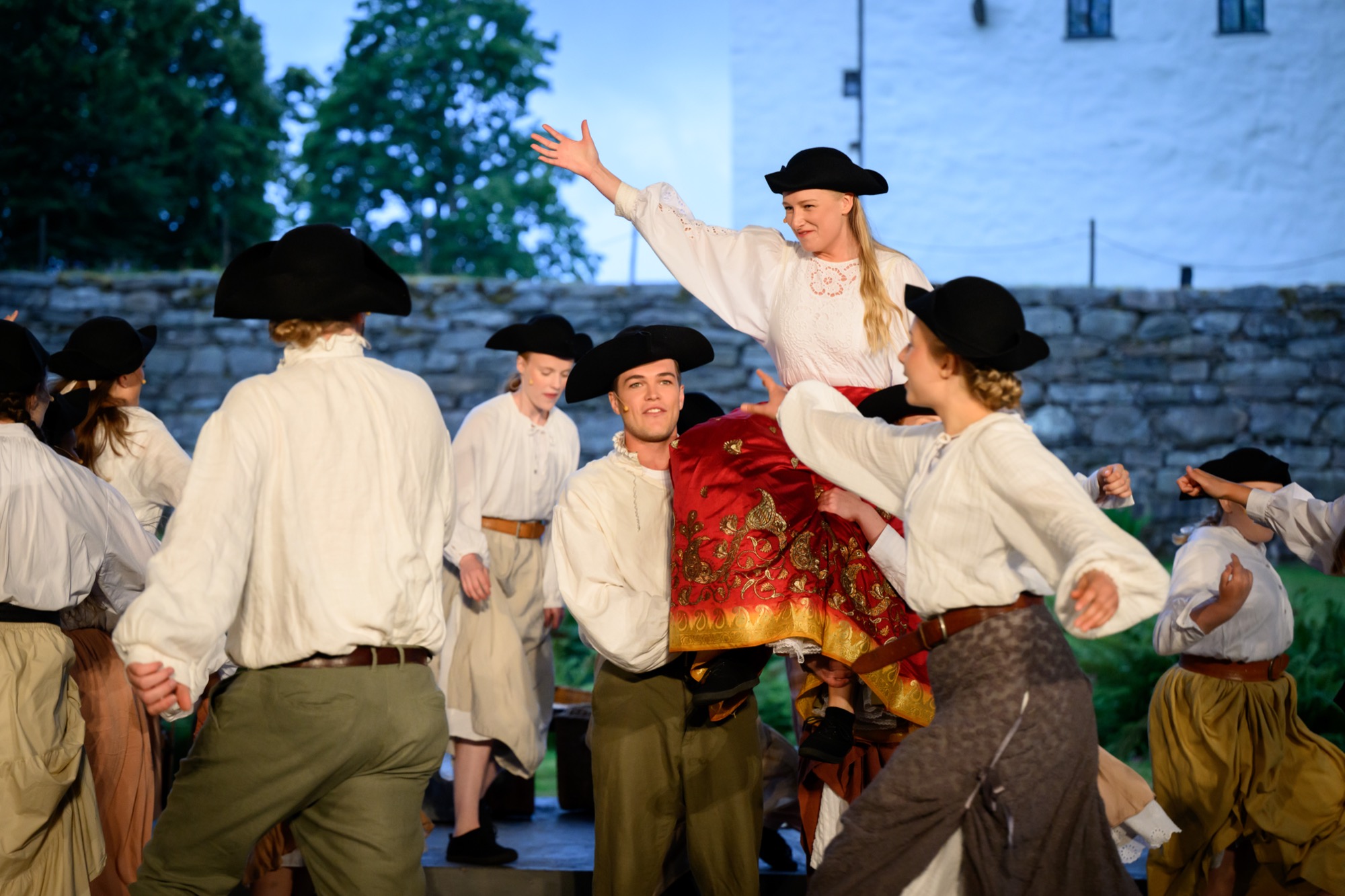 Ensemblen dansar och lyfter Cecilia Vasa framför Torpa Stenhus